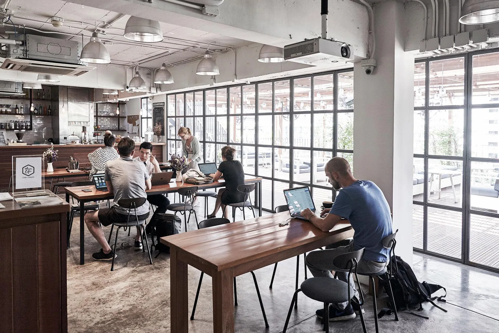 Rooftop garden space at The Hive Thonglor with wooden decking and seating