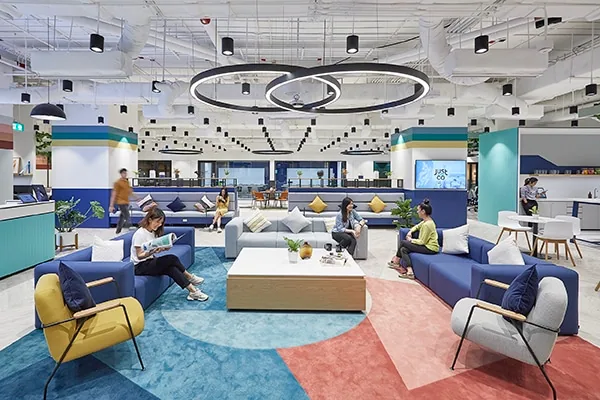 Bright reception area at JustCo Gaysorn Amarin with curved desk and soft seating